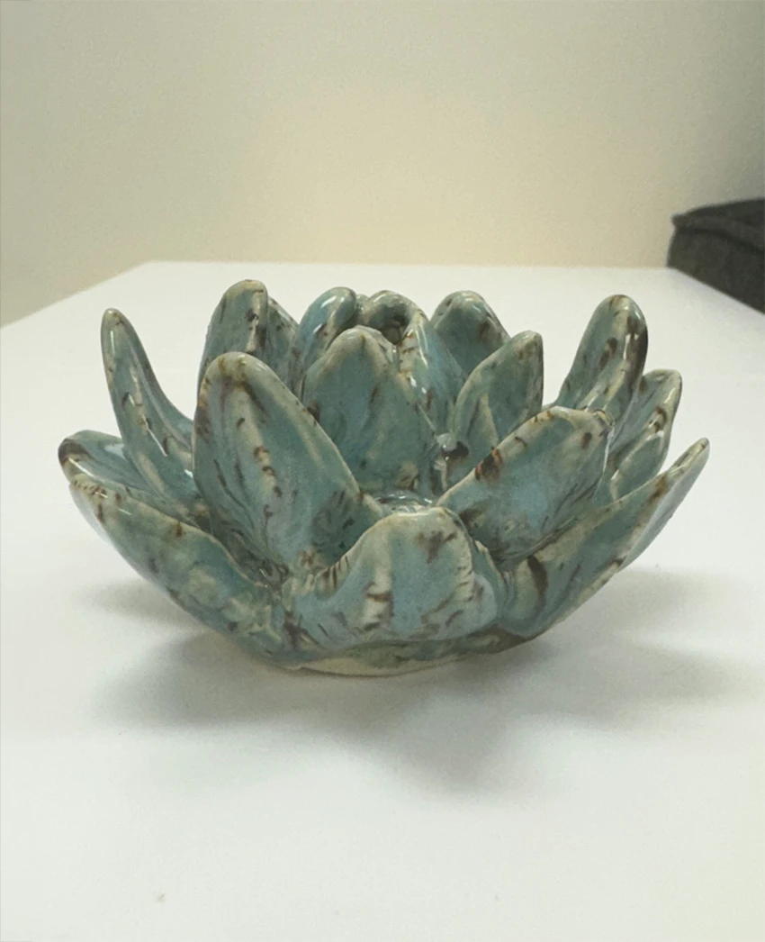 A glazed ceramic lotus-style sculpture in soft blue-green
